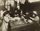 Lewis Hine, This was the high-tide of tenement homework in New York City when children like these worked at flower-making, picking out nut-meats and many other and many other things long days and even into the night,(this was going on at 8;00 P.M.) Their schooling, health and recreation suffered very much.