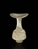 Vase with flaring lip and diagonally fluted body by Lucie Rie, circa 1976, Stoneware, reactive elements in the body producing a pitted effect in the white glaze, sold Jun 2013