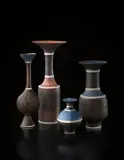 Tall cylindrical vase with flaring rim by Lucie Rie, circa 1972, Porcelain, manganese and terracotta glazes, sgraffito on the lip and shoulder, with three bands of blue inlay, sold Dec 2013
