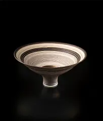Flaring footed bowl by Lucie Rie, circa 1980, Porcelain, golden manganese glaze with concentric bands of inlay and sgraffito, sold Dec 2013