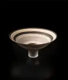 Flaring footed bowl by Lucie Rie, circa 1980, Porcelain, golden manganese glaze with concentric bands of inlay and sgraffito, sold Dec 2013