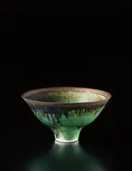 Footed bowl by Lucie Rie, circa 1978, Porcelain, bottle green glaze with golden lip, sold Dec 2013