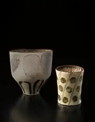Beaker vase by Lucie Rie, circa 1954, Porcelain, inlaid "chord and disc" design beneath pale yellow glaze, sold Dec 2013