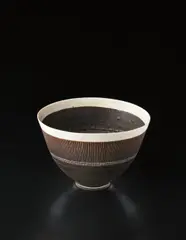 Deep bowl by Lucie Rie, circa 1956, Porcelain, manganese and white glazes, with a deep band of fine sgraffito design, sold Dec 2013