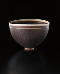 Deep bowl with oval lip by Lucie Rie, circa 1956, Porcelain, manganese glaze, sgraffito and inlaid bands at the lip, sold Dec 2013