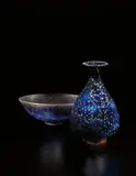 Bowl, 1958, and bottle with flaring top by Gertrud Natzler and Otto Natzler, 1959, Bowl: earthenware, dark blue glaze with crystal formations, fire marks and smoke traces; bottle: earthenware, dark blue , sold Dec 2013