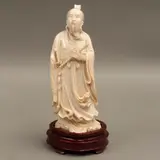 CHINA, SIGLO XX by Sabio Anciano Con Cetro y Espada, Talla en marfil, decoración esgrafiada, tinta negra; con base de madera, sold Nov 2023