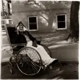 Diane Arbus, Masked woman in a wheelchair, P.A.