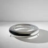 'Ring' low table by Elizabeth Garouste and Mattia Bonetti, 1999, Mirror-polished stainless steel, glass, sold May 2024