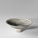 Large 'New Knitted' bowl by Lucie Rie, circa 1980, Stoneware, inlaid with a radiating manganese design beneath a white dolomite glaze, sold May 2024