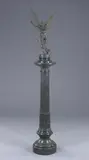 Maria Zambaco, Amour Irresistible, Grey-green patinated metal, on a black marble column. - Full height, approx: 71 in.; bronze height: 26 in