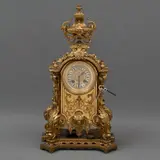 Reloj de Mesa, FRANCIA, PRINCIPIOS DEL SIGLO XX, Bronce dorado, estilo IMPERIO, marca JAPY FRERES. Profusamente decorado con relieves florales, vegetales y mascarón; medía sonería, carátula con números romanos porcelanizados