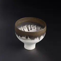 Footed bowl by Lucie Rie, circa 1980, Porcelain, pure matt white glaze with a golden manganese rim, sold Apr 2023