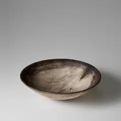 Large bowl by Hans Coper, 1956, Stoneware, layered porcelain slips over a textured body, sgraffito design in the well and manganese rim, sold Nov 2023