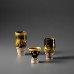 Three early vases by Hans Coper, circa 1952, Stoneware, impressed circles beneath yellow and manganese flowing glazes, sold Nov 2023