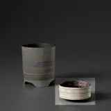 Bowl by Lucie Rie, circa 1958, Porcelain, manganese glaze with sgraffito, impressed and inlaid circles within horizontal bands, sold Nov 2023