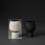 Bulbous pot on cylindrical foot with internal stem holder by Hans Coper, circa 1974, Stoneware, layered white porcelain slips and engobes over a textured and incised body, the interior with manganese glaze, sold Nov 2023