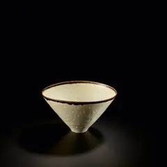 Conical 'Rice' bowl by Lucie Rie, 1958, Porcelain, shiny white glaze with manganese lip, the glaze flowing into pierced holes in the body, sold Nov 2023