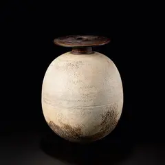 Hans Coper, Large ovoid pot with disc top, circa 1965, Stoneware, layered white porcelain slips and engobes over a textured and incised body, the neck and disk with manganese glaze
