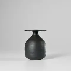 Bottle with disc top by Hans Coper, circa 1962, Stoneware, black glaze over a textured and incised body, sold Nov 2023
