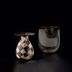 'Sack and Disc' form by Hans Coper, circa 1972, Stoneware, layered porcelain slips and engobes over a textured body with a painted manganese chequered design, the disc , sold Nov 2023