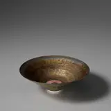 Conical bowl by Lucie Rie, circa 1969, Porcelain with golden glaze and terracotta sgraffito well, sold Nov 2023