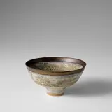 Footed bowl by Lucie Rie, circa 1986, Stoneware, volcanic grey glaze, golden manganese band around lip, sold Nov 2023