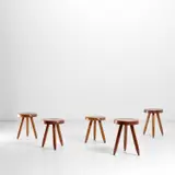 Five high 'Berger' stools by Charlotte Perriand, circa 1953, Four in African mahogany and one in beech, sold May 2022