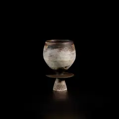 Cup with central disc by Hans Coper, circa 1965, Stoneware, porcelain slips and manganese over a textured body, the interior with a manganese glaze, sold Nov 2022