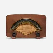 Radio, model 8H034 by Charles and Ray Eames, 1946, walnut veneer, plastic, cloth, sold May 2025