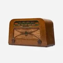 Radio, model A309 by Charles and Ray Eames, c. 1946, combed oak, plastic, Bakelite, brass, silk, sold May 2025