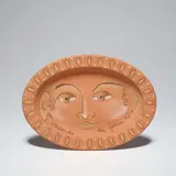 Visage ovale (Oval Face) (G. 240) by Jean Cocteau, 1958, Red earthenware oval dish with crayon d'oxyde additions, sold Jan 2021