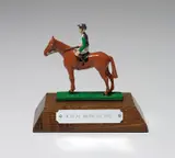 Mark Wallinger, A Real Work of Art, 1993, Die-cast metal statuette painted in colours, on a wooden base with metal plaque