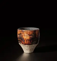 Cup by Hans Coper, circa 1954, Stoneware, porcelain slips and engobes over a textured body with treacle glaze over incised spiral, the interior with ma, sold Nov 2021