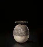 Ovoid pot with disc top by Hans Coper, circa 1972, Stoneware, layered porcelain slips and engobes over a textured body, the neck and disc with manganese glaze, sold Nov 2021