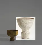 Footed vessel by Lucie Rie, circa 1976, Stoneware mixed with manganese minerals beneath a flowing white glaze creating a pitted texture, sold Nov 2021