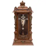 Cristo, INDIA-PORTUGAL CA., 1900, Talla en marfil esgrafiado y entintado. Incluye cruz de madera, resplandor, bordes y remate de plata con pedrería; nicho tallado con pantallas de vidrio y aplicaciones de bronce a manera de estípites con seres fitomorfos y motivos vegetales