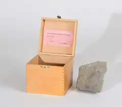 Robert Filliou, Optimistic Box No.1 Thank god for modern weapons, 1968, Multiple. Kleine Holzkiste und dunkler Naturstein
