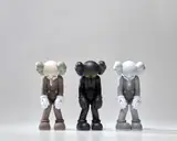 Kaws, Three works: (i) SMALL LIE (Brown) ; (ii) SMALL LIE (Black) ; (iii) SMALL LIE (Grey), 2017, painted vinyl, in original Medicom packaging