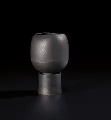 Pot on cylindrical foot by Hans Coper, circa 1974, Stoneware, black glaze, the interior with a cylindrical stem-holder, sold Nov 2020
