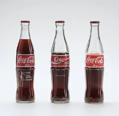 Interções em Circuitos Ideolõgicos: Projeto Coca-Cola by Cildo Meireles, 1970, transfer text on Coca-Cola glass bottle, in 3 parts, sold Oct 2019