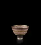 Footed bowl by Lucie Rie, 1985, Porcelain, golden manganese glaze, two terracotta bands crossed with vertical sgraffito lines, terracotta well and a tur, sold Oct 2019
