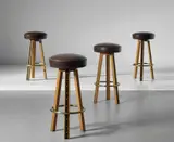 Jean Royere, Set of four stools, 1950s, Oak, painted wood, leather, brass-plated steel, brass