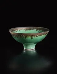 Footed bowl by Lucie Rie, circa 1980, Porcelain, green glaze with golden manganese lip, sold Oct 2018
