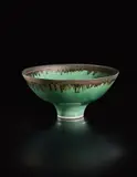 Footed bowl by Lucie Rie, circa 1980, Porcelain, green glaze with golden manganese lip, sold Oct 2018