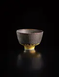 Footed bowl by Lucie Rie, circa 1965, Porcelain, yellow and manganese glazes, with sgraffito on the exterior and the interior, sold Oct 2018