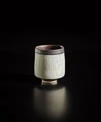 Sake cup by Lucie Rie, 1960s, Porcelain, inlaid blue lines, manganese interior and foot, sold Oct 2018