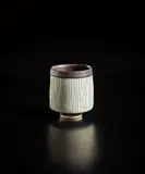 Sake cup by Lucie Rie, 1960s, Porcelain, inlaid blue lines, manganese interior and foot, sold Oct 2018