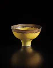 Footed bowl by Lucie Rie, 1983, Porcelain, yellow glaze with golden manganese lip, sold Oct 2018