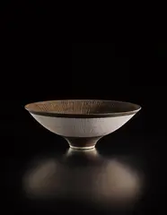 Footed open bowl by Lucie Rie, late 1970s, Porcelain, golden manganese glaze, radiating inlaid and sgraffito design, sold Oct 2018